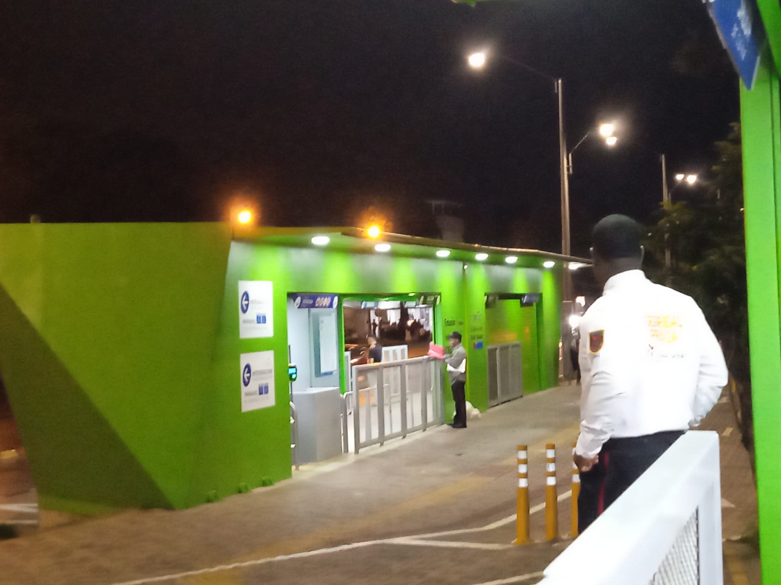 Guardia de seguridad de espaldas vigilando el acceso de las personas a una estación del MIO