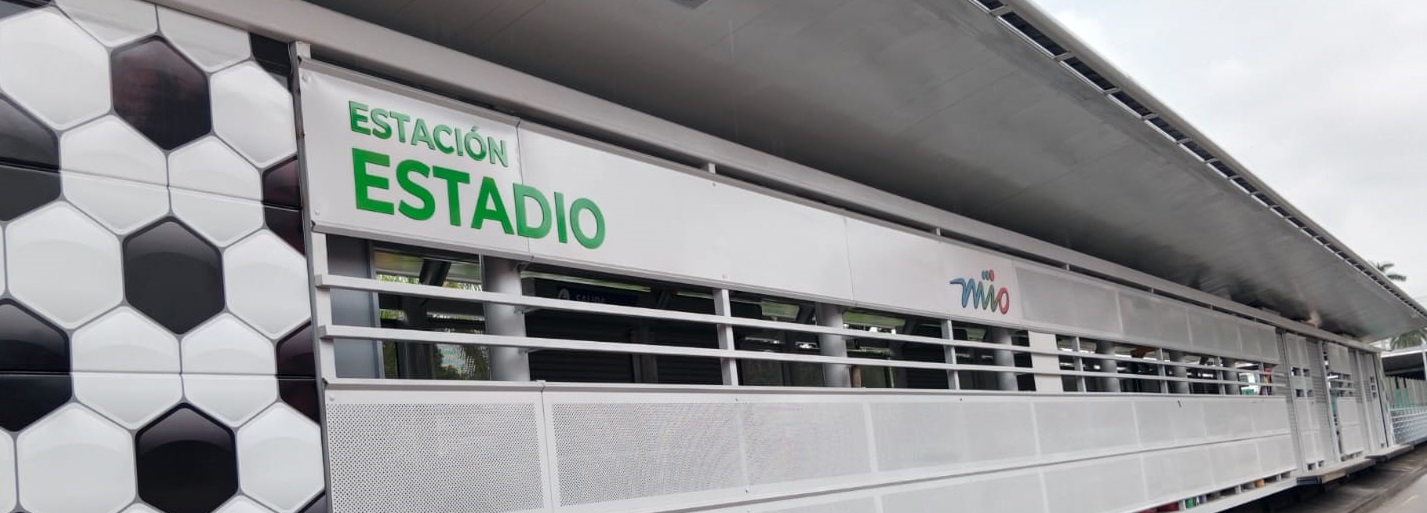 Foto en la cual se ve el nombre de la estación Estadio, el logo del MIO y parte de la estación del lado derecho.