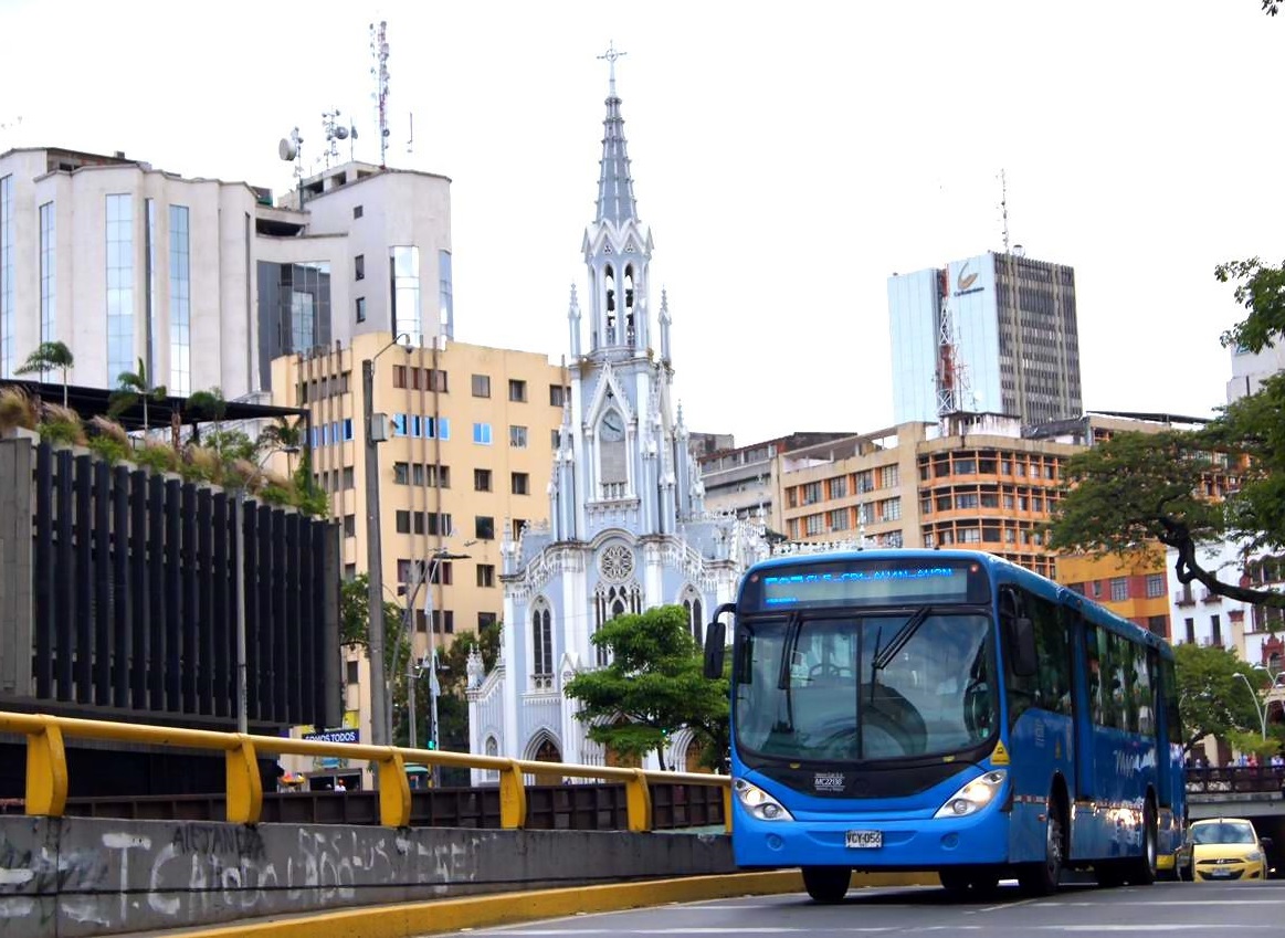 Foto en la cual se ve un bus del MIO por el túnel Mundialista y al fondo la iglesia La Ermita.