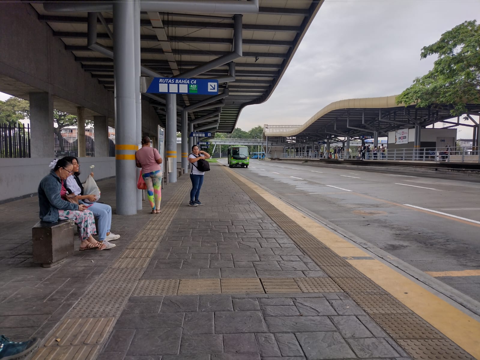 Foto de la Terminal Paso del Comercio en la cual se ve a usuarios y un bus alimentador del MIO.