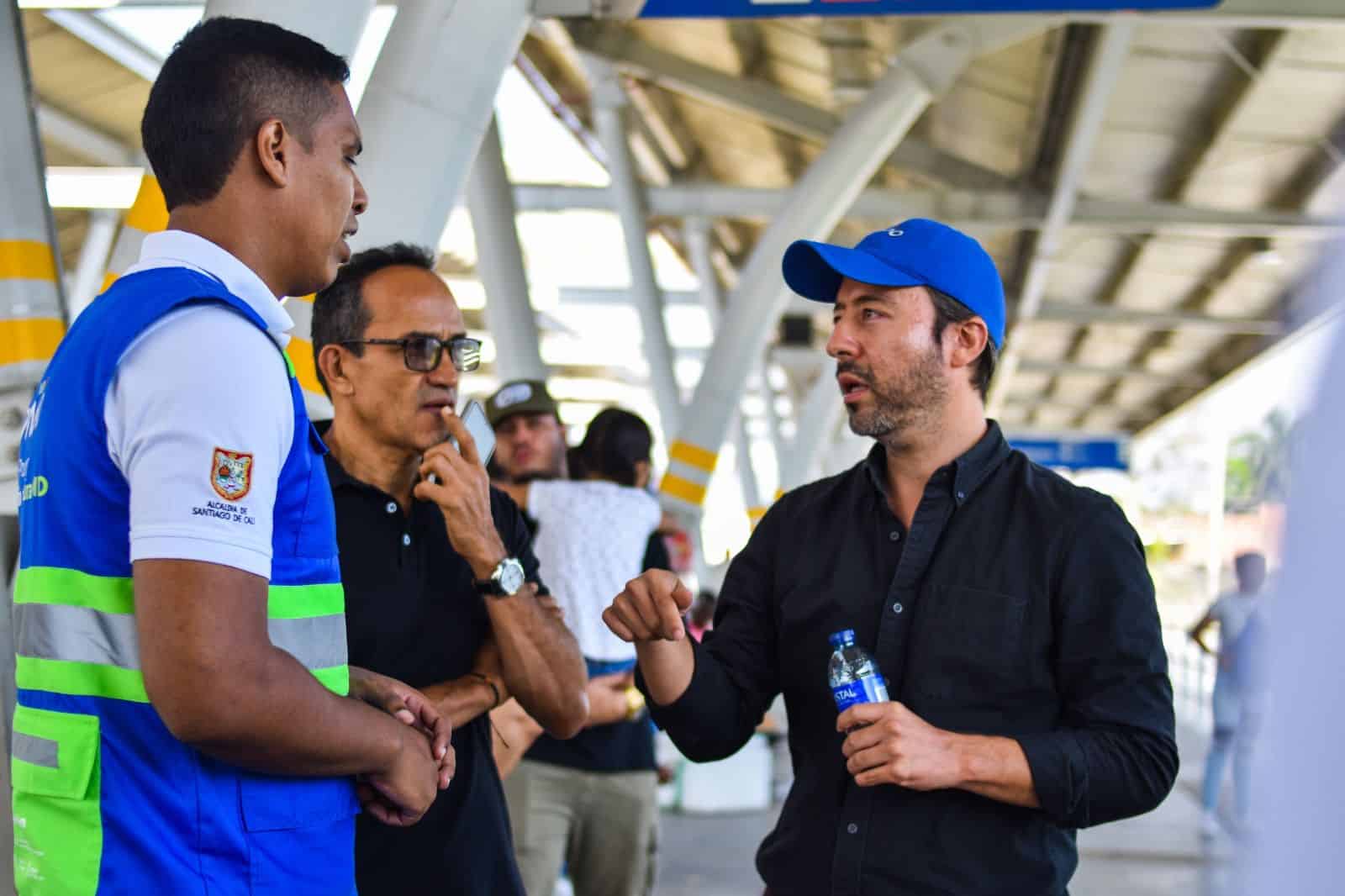 En la foto se ve al presidente de Metro Cali hablando con dos personas, entre ellos, un asesor de servicio en una de las estaciones del MIO.