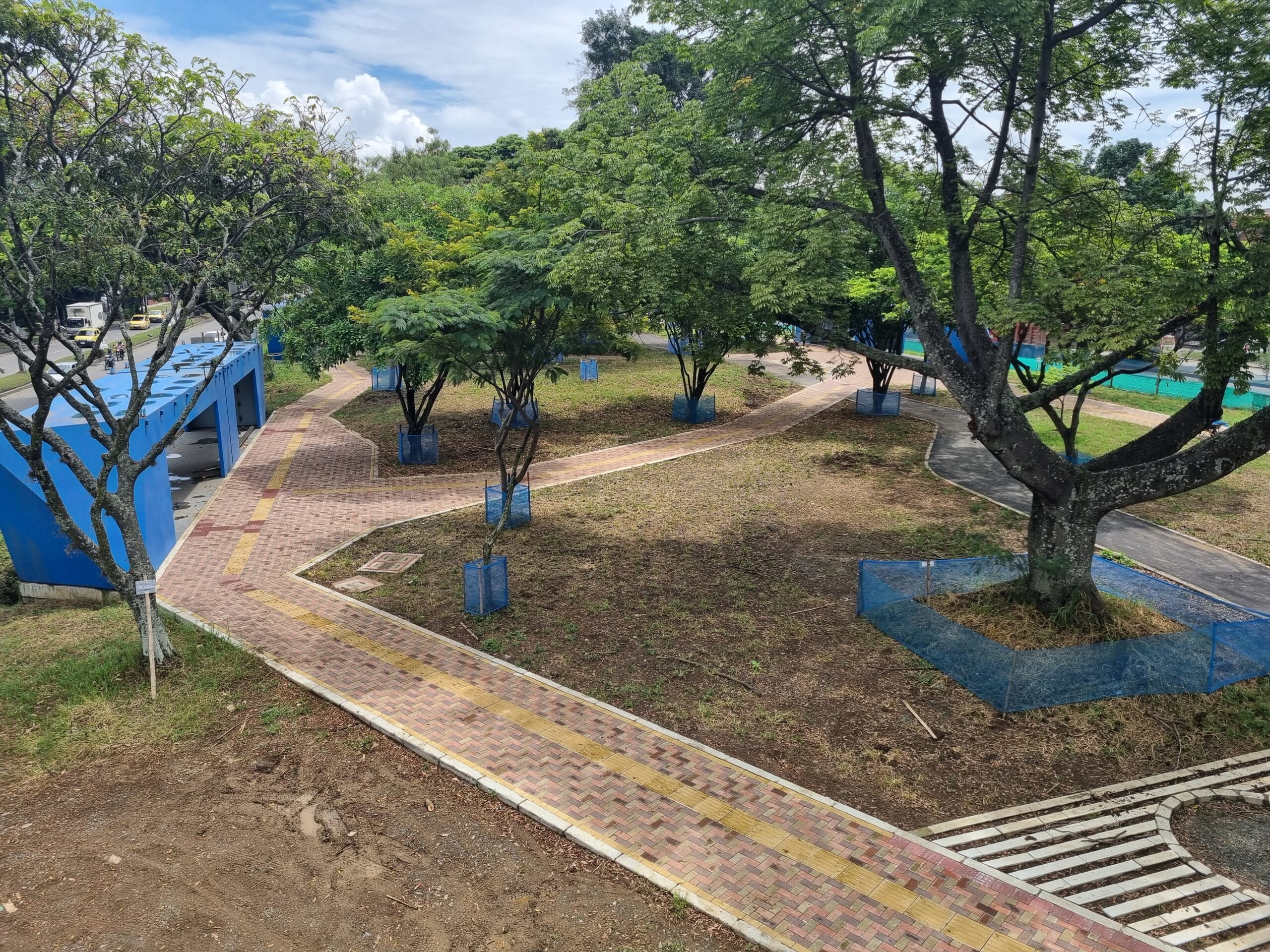 Foto donde se ve un parque con sendero peatonal y una estación de Troncal Oriental.