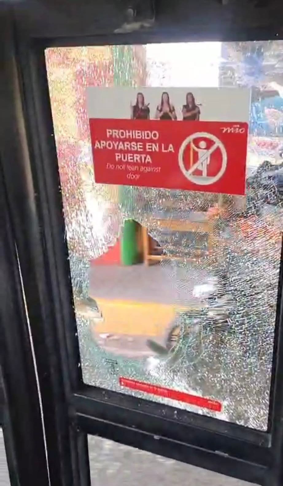 Foto donde se ve un vidrio del bus del MIO quebrado.
