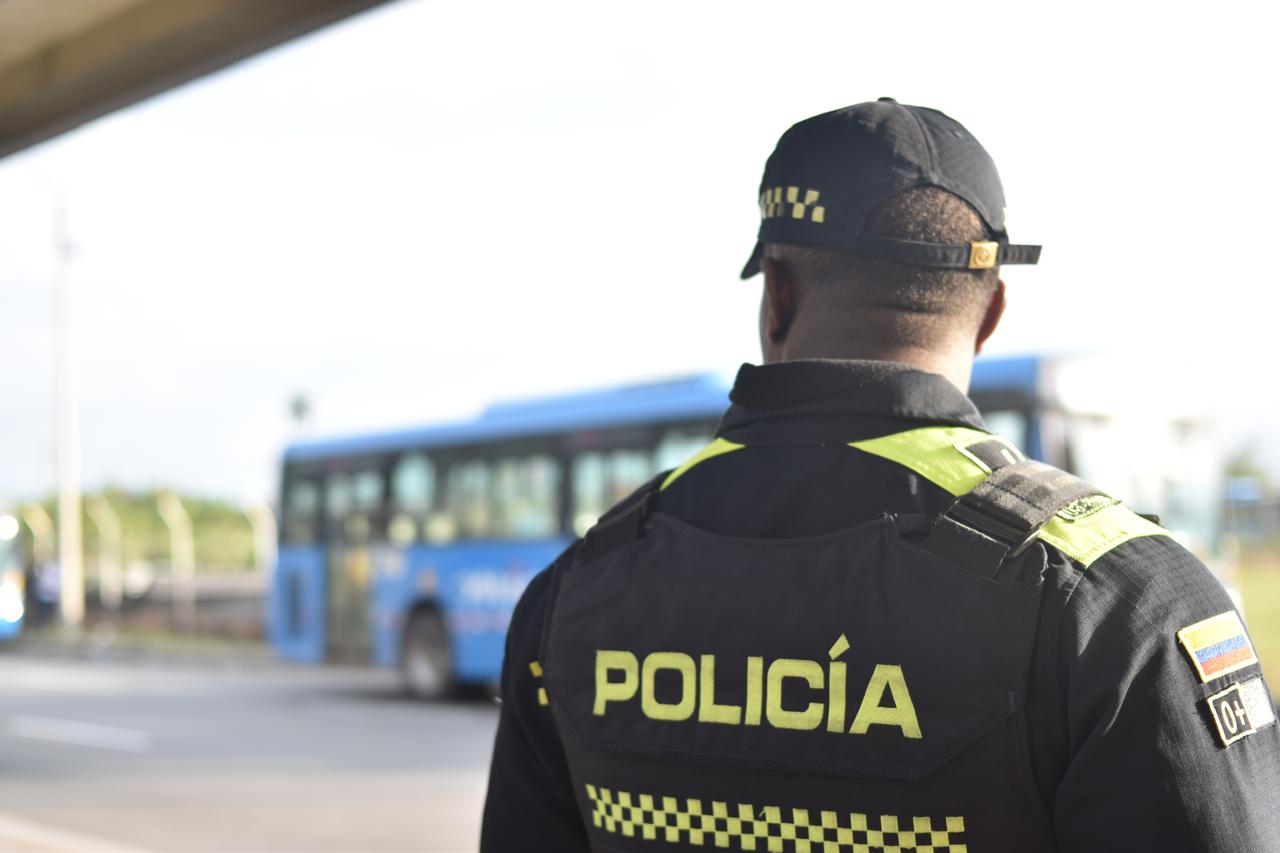 Foto en la cual se ve a un policía de espalda y al fondo un bus del MIO.
