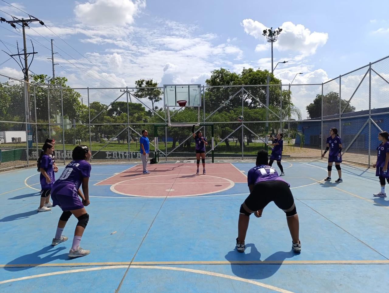 Foto en la cual se ve a un grupo de niñas en una cancha jugando basquetbol.