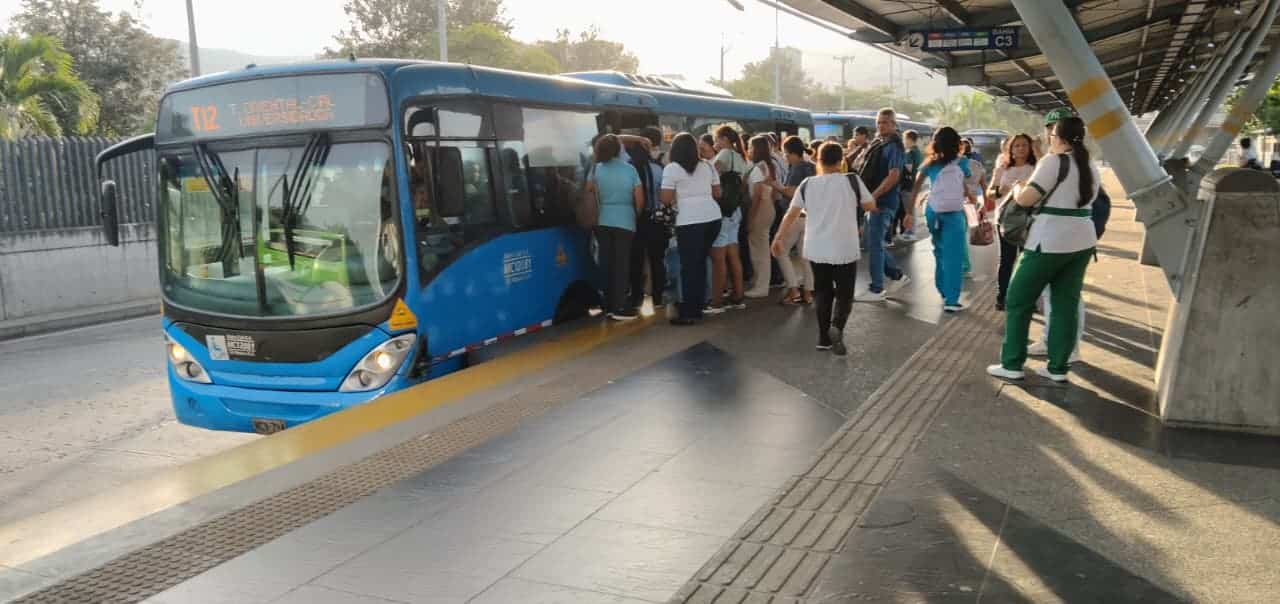 Foto de la Terminal Menga en la cual se ve usuarios subirse a un bus articulado.