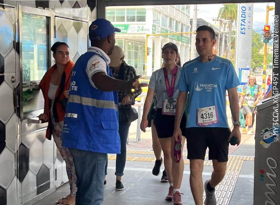 Foto en la entrada de la estación Estadio, en la cual una persona del sistema le indica a los atletas cómo ingresar.