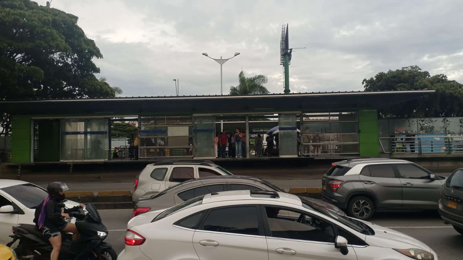 Foto en la cual se ven vehículos particulares por el carril mixto y la estación Capri con usuarios esperando el bus.