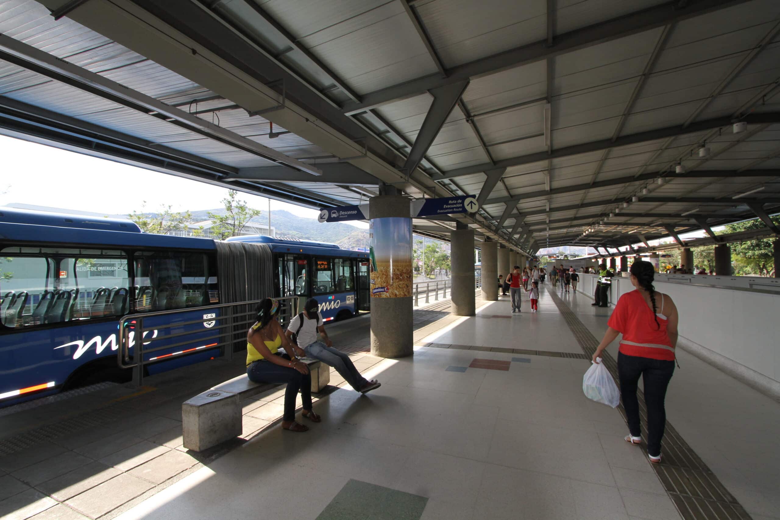 Foto en la cual se ve un bus del MIO en la estación Unidad Deportiva y usuarios en ella.