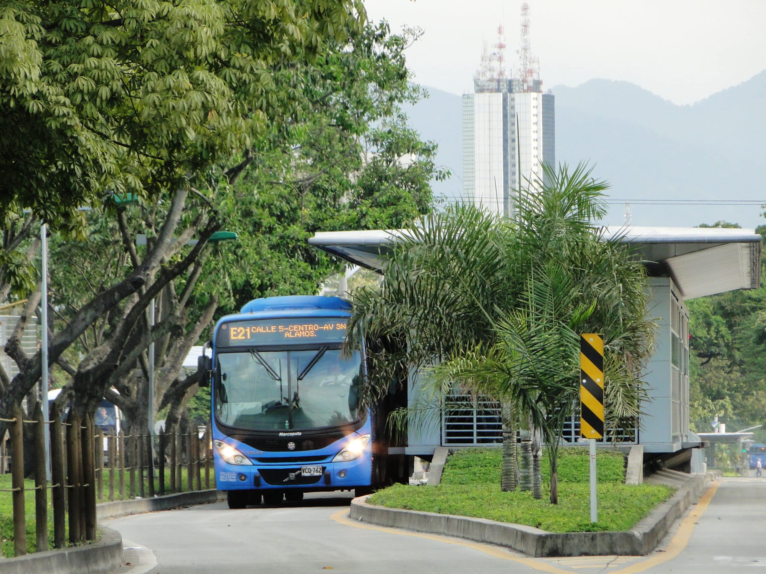 Foto en la cual se ve un bus articulado en una estación esperando pasajeros.
