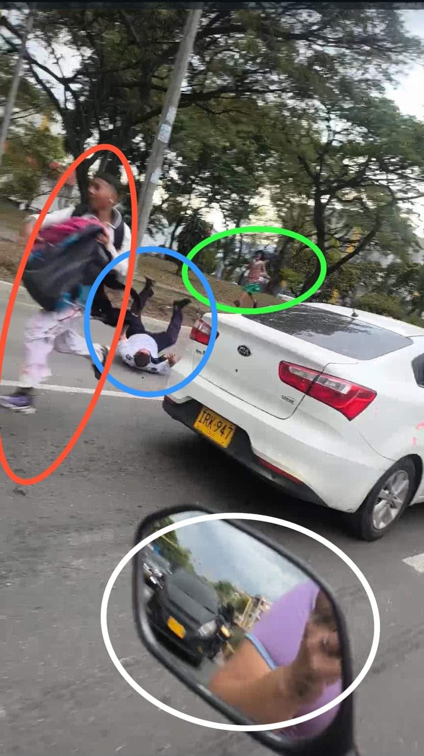 Foto en la cual se observa al conductor del MIO en el piso, carril mixto. Así como personas y vehículos.